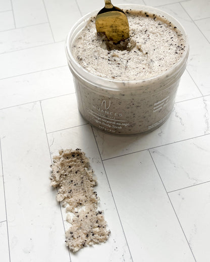 An open jar of the vegan coffee body scrub with an example of the texture on the white background